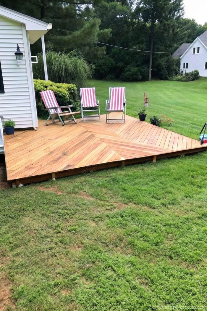 Élégante terrasse en bois avec motif en chevrons, chaises rayées entourées de verdure et d’arbres, créant un espace extérieur paisible.