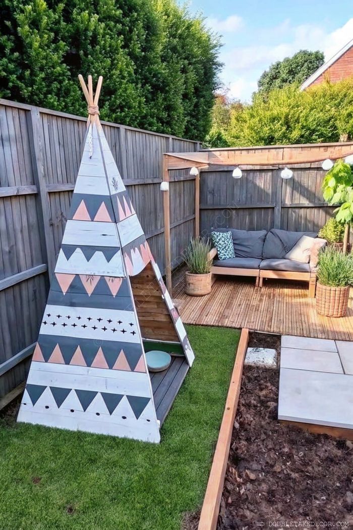 Terrasse en palettes avec tipie pour enfants et canapé d’angle gris, décorée de guirlandes et de verdure pour des moments en famille.