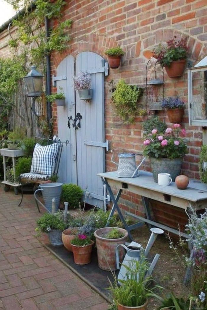 Charming garden nook with blue doors against brick wall, hanging plants, cozy bench, and wooden table with gardening essentials