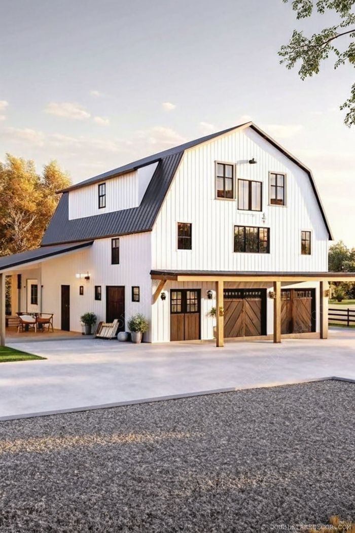 Modern farmhouse fehér külsővel, fekete díszítésekkel, pajta-tetővel és rusztikus fa elemekkel, dús kerttel körülvéve.