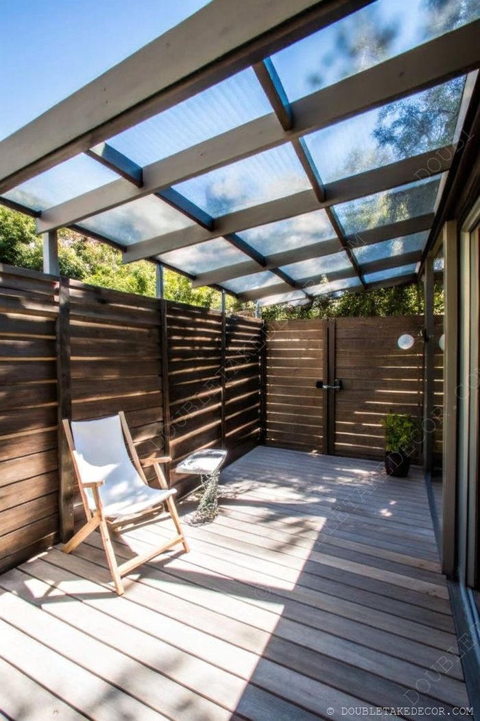 Serene wooden deck with transparent roof, featuring a comfortable chair, side table, and potted plant for relaxation.