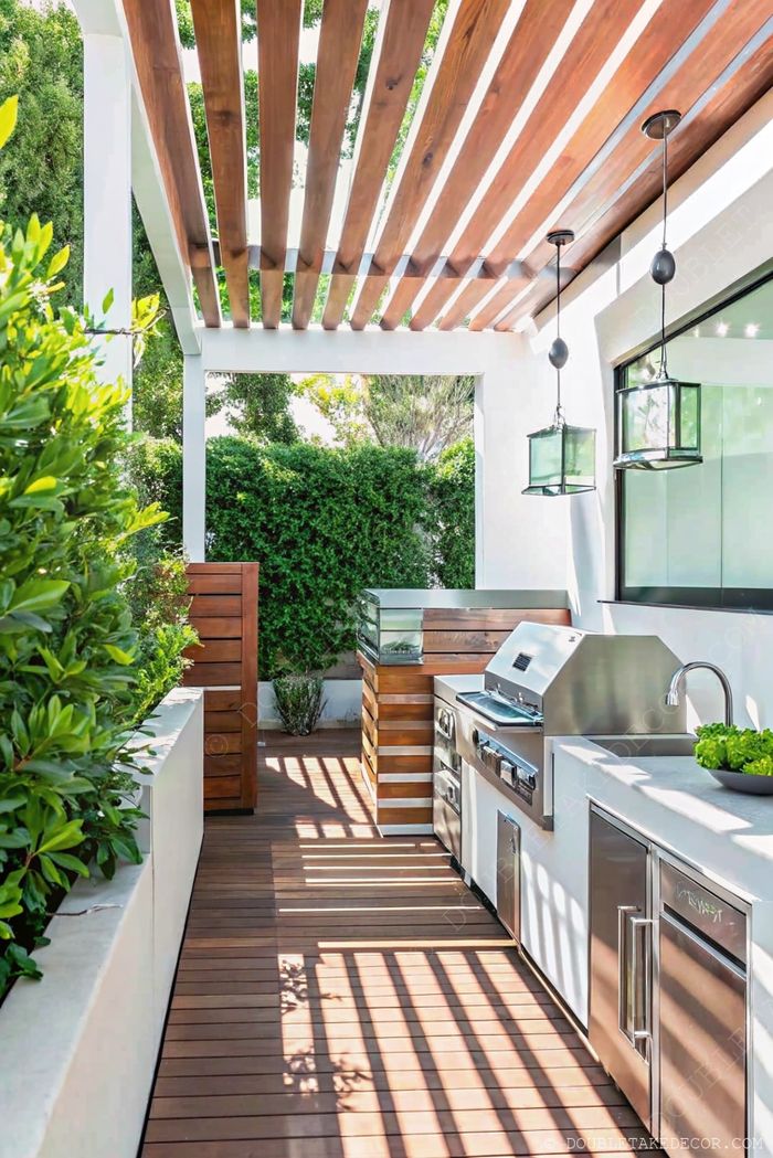 Stylish outdoor kitchen with wooden pergola, stainless steel grill, slatted storage, and natural greenery for privacy