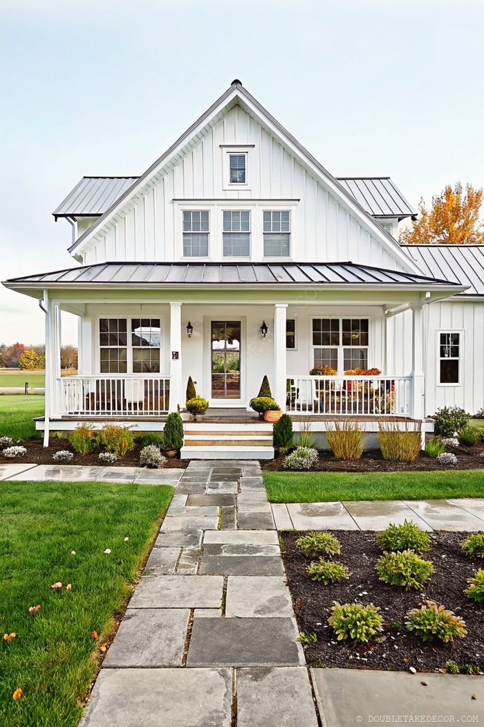 Charming modern farmhouse with white siding, wraparound porch with white railings, and landscaped flower beds along a stone pathway.