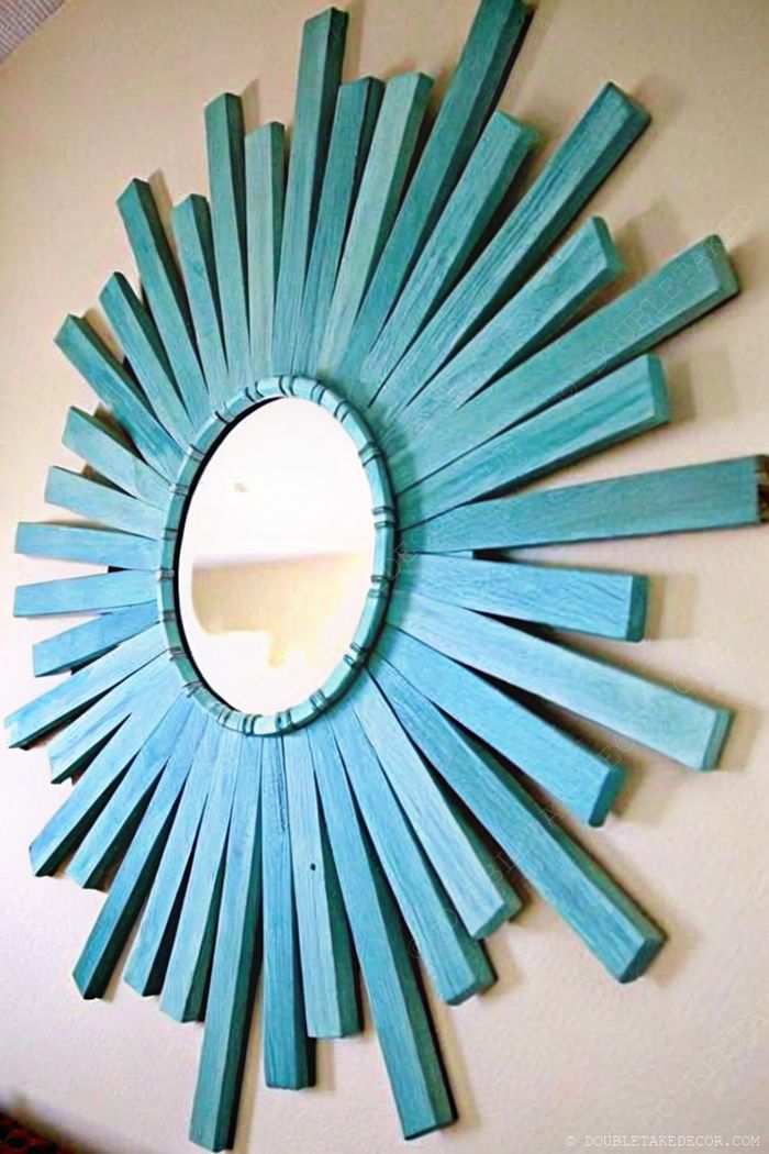 Decorative mirror with teal-painted wooden slats in a radiant sunburst design, perfect for nautical coastal decor.