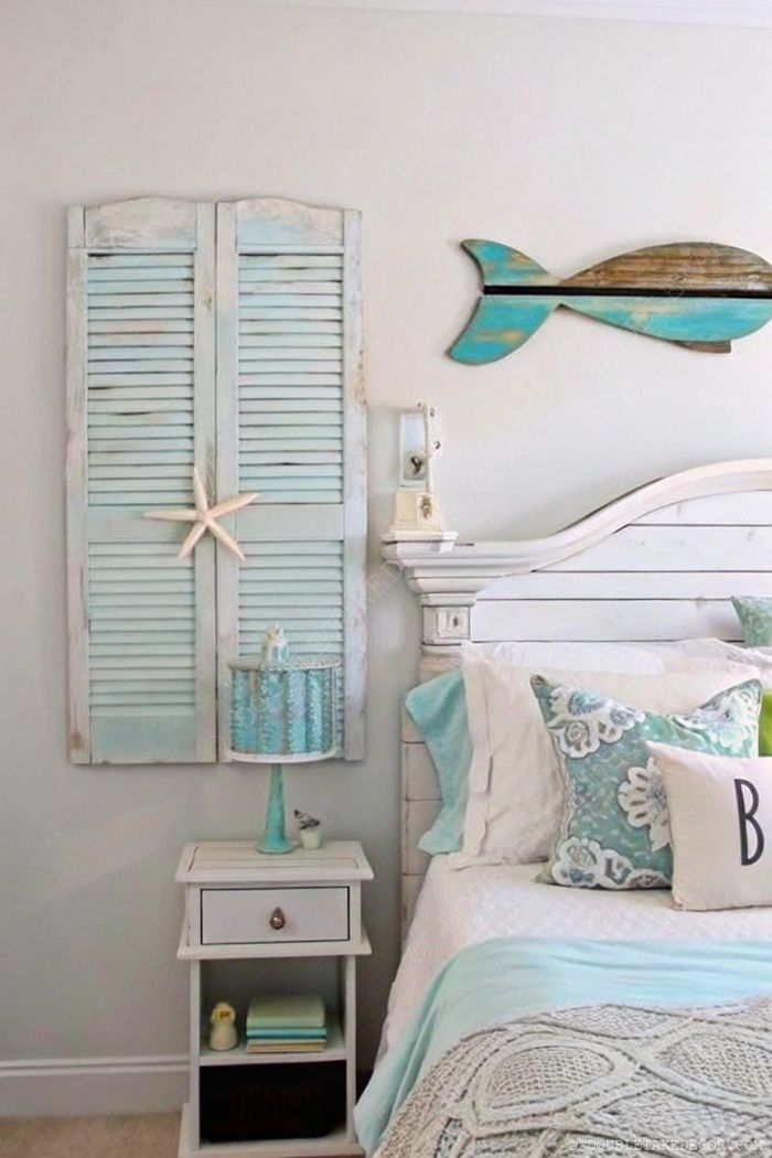 Coastal-themed bedroom with blue wooden shutters, starfish accent, and seafoam green bedding creating a tranquil beach aesthetic.