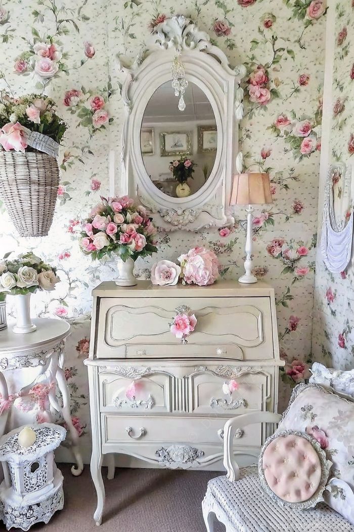 Romantikus shabby chic szoba virágos tapétával, krémszínű íróasztallal, díszes tükörrel és finom virágdekorral–otthonos hangulat.