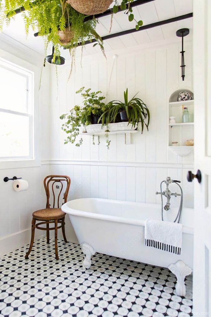 Stylish farmhouse bathroom with freestanding tub, patterned floor, hanging plants in baskets, and wooden accents creating a serene atmosphere.