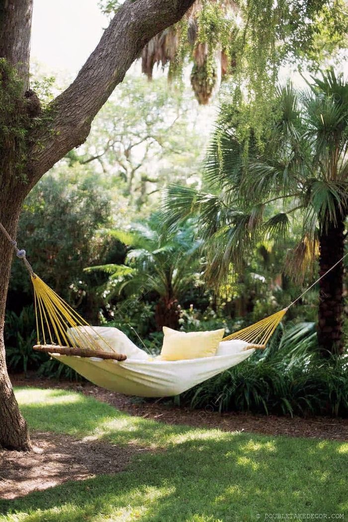 Hamac paisible avec coussins jaunes suspendu entre des arbres, entouré de feuillages tropicaux pour un vrai coin nature.