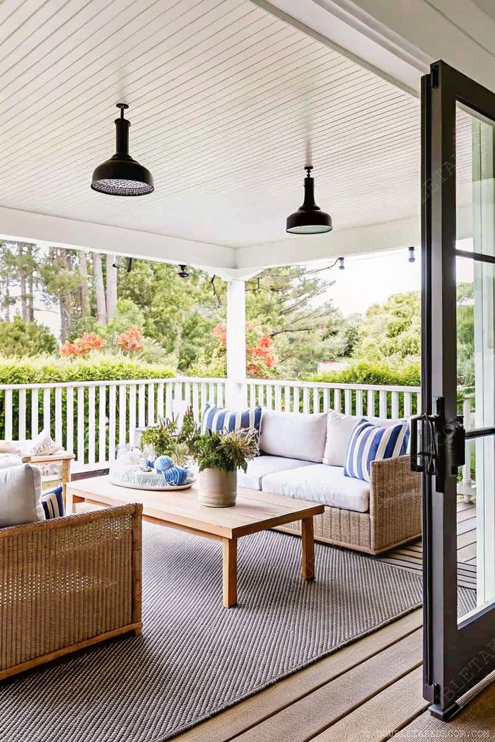 Outdoor porch with pendant lighting illuminating a comfortable seating area with striped cushions and natural elements