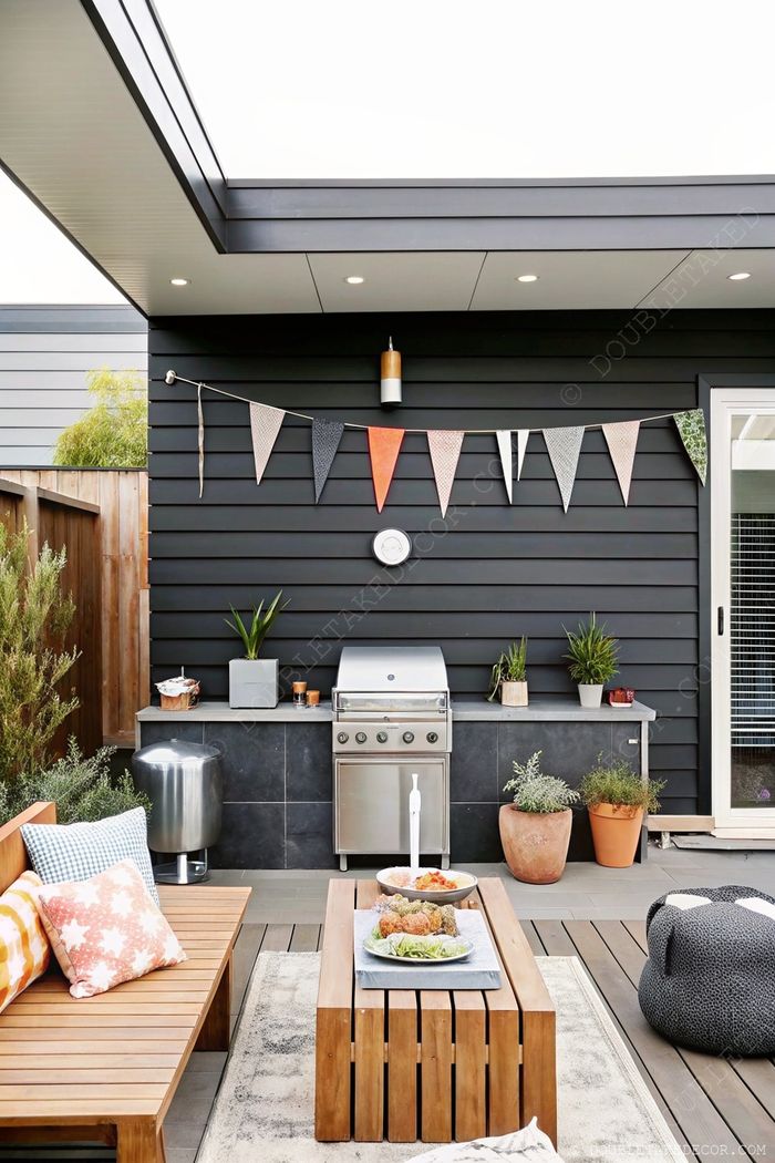 Stylish porch with dark wood accent wall, barbecue station, bunting flags, and comfortable bench seating with pillows.