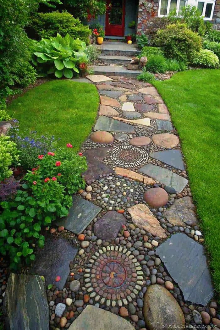Meandering garden pathway with polished and rough stones, surrounded by lush greenery, vibrant flowers, and decorative pebble arrangements.