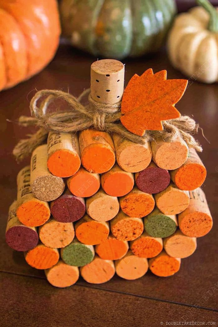 Autumn-themed decorative pumpkin crafted from painted wine corks in warm fall colors with a jute stem and leaf accent