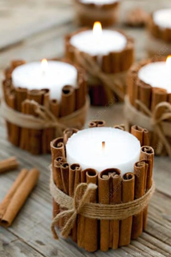 Rustic fall decor featuring candles surrounded by cinnamon sticks tied with twine, creating a warm, cozy ambiance perfect for autumn.